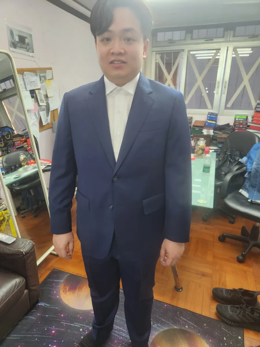 Cliente probándose un traje azul marino a medida